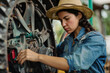 © wolfhound911 - Latino woman fixing a tractor wheel. Modern farmer working independently on her agricultural machinery. Women's contribution to farming.