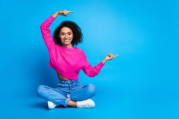 Sticker - Full size photo of pretty young girl sit floor point empty space wear trendy pink outfit isolated on blue color background