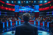 © ivlianna - A televised debate between political opponents discussing key issues facing the nation .A man in a suit is speaking on stage in front of a blue crowd at the field house