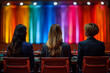 © ivlianna - Candidates participating in televised town hall forums, responding to questions from undecided voters .Three women enjoy the event on magenta chairs in front of a colorful stage