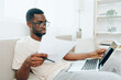 © SHOTPRIME STUDIO - Smiling African American Man Freelancer Working on Laptop in Modern Home Office