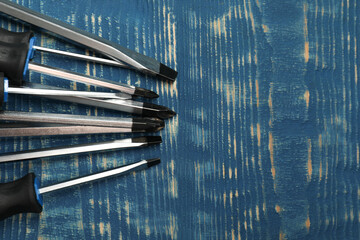 Wall Mural - Set of screwdrivers on blue wooden table, flat lay. Space for text