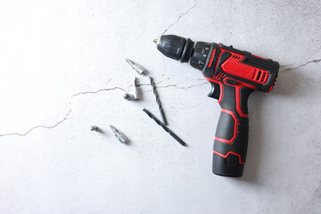 Modern electric screwdriver and bits on grey table, top view