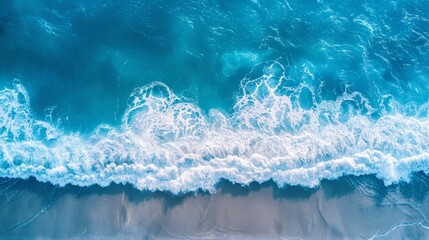 Wall Mural - Aerial view of ocean waves crashing on a sandy beach, showcasing the beauty of nature. Ideal for travel, summer, and coastal themes and backgrounds