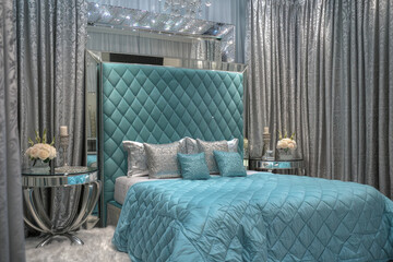 Wall Mural - Glamorous art deco bedroom with a quilted turquoise headboard, mirrored side tables, and silver damask curtains.