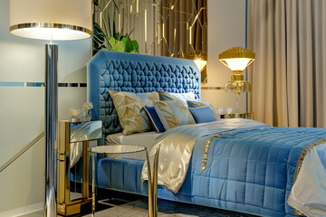 Wall Mural - Refined art deco bedroom with a quilted electric blue headboard, mirrored side tables, and a gold patterned floor lamp.