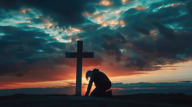 silhouette of man kneeling in worship before illuminated cross in dramatic cloudy sky spiritual faith concept