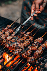 Wall Mural - close up person grilling meat and vegetables on backyard with family and friends, barbecue summer weekend time, outdoor party wallpaper, picnic banner