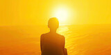 Fototapeta  - Sunset Yellow Transformation: Embrace the Light - A person sits in front of a breathtaking sunset, their back turned towards the viewer, radiating warmth and optimism in the golden yellow light