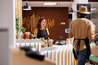 © DC Studio - Happy vendor awaiting clients in zero waste store designed to minimize plastic usage, creating positive environmental impact. Cheerful seller and coworker selling ethically sourced pantry staples