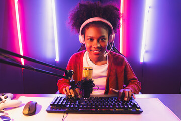 Wall Mural - Host channel of gaming streamer, African girl taking, typing with Esport skilled team player and viewers online game in neon color lighting room. Concept of cybersport indoor activities. Tastemaker.