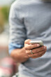 © peopleimages.com - Man, hands and typing with phone for communication, browsing or social media in nature. Closeup of male person on mobile smartphone in online chatting, texting or app for contact, share or research