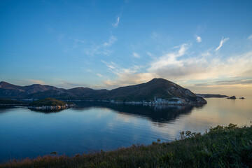 World heritage port davey national park in tasmania Australia, with mountains and river. boats in a bay in the evening