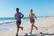 © Wavebreak Media - At beach, diverse couple jogging, enjoying exercise