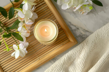 A glass candle jar mockup, top view, placed on a bamboo tray with soft, natural lighting in a spa center, evoking a sense of calmness and natural beauty, perfect for a spa atmosphere. 