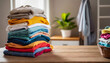 © Your Hand Please - stack of clothes on table, symbolizing laundry chores, household organization, and decluttering