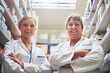 © peopleimages.com - Teamwork, pharmacists or portrait of women with arms crossed in healthcare clinic, pharmacy or drugstore. Proud, wellness or confident doctors by shelf for medication, pills or medicine ready to help