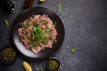 Wall Mural - tuna carpaccio - slices of fresh raw tuna fillet on black ceramic plate