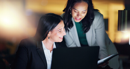 Wall Mural - Laptop, tablet and collaboration with business people at night in the office together for teamwork. Technology, smile and a happy employee team of women working on a project or report in the evening