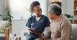 © peopleimages.com - Tablet, healthcare and african nurse in home with senior man, internet and online help on sofa. Young caregiver, elderly person and technology for learning or telehealth and care in chronic illness