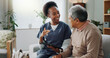 © peopleimages.com - Nurse, senior and consulting with tablet on sofa for healthcare, communication or consultation at home. Woman or medical caregiver talking to elderly male person with technology for advice or help