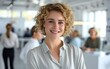 © Mayura - Portrait of happy Portrait of young woman smiling standing in modern office space.
