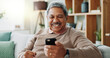 © peopleimages.com - Senior, happy man and winning with phone for online bingo, prize or lottery in financial freedom or retirement at home. Excited male person with smile for mobile smartphone, celebration or good news