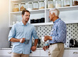 © peopleimages.com - Man, advice and senior father in kitchen with conversation in morning with coffee for help or consult in retirement. Proud, dad and son on weekend together in home for family dinner in Switzerland.