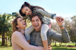 © peopleimages.com - Family, parents and girl in park for piggyback, playing and bonding together with smile. Happy people, mother and father with child outdoor in nature for relaxing, recreation or physical activity
