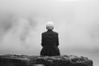 © Eric - Grey Area - A lone elderly individual sitting on a rock by a misty lake