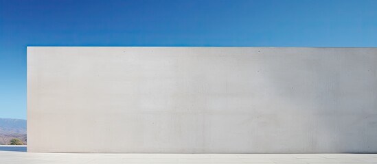 Poster - A contemporary abstract structure with a copy space image set against a backdrop of a clear blue sky and a solid cement wall