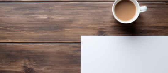Poster - On a wooden table there is a cup of coffee and a notepad with ample copy space image