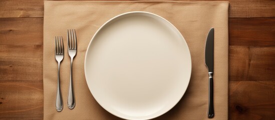 Poster - A top view of a table setting with an empty plate a knife a fork and a napkin providing ample copy space for customization