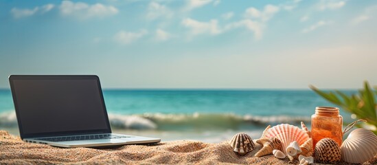 Fototapete - A laptop surrounded by beach accessories and seashells represents the vacation travel and summer concept in this copy space image