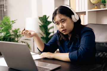 Happy student, studying for MBA exam, takes advantage of distance learning to attend school from home, balancing training and class. Woman studies book and research for online academy using laptop.