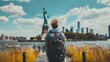 © YUTTADANAI - A backpacker admiring the Statue of Liberty from a distance, with the famous landmark in the background, depicted in a soft focus stock photo to showcase the joy of travel.