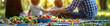 © Carles - Vegetable and fruit foods focused with a family in the background in a natural park, summer concept vacation concept holidays