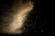 © Free Life Design - Yellow sand fly wave in the air. Golden sand explosion isolated on black background. Abstract sand cloud. Golden colored sand splash against dark background.