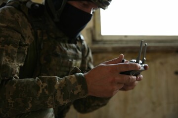 Wall Mural - Military mission. Soldier in uniform with drone controller inside abandoned building