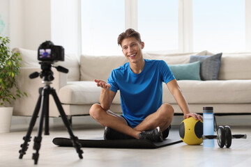 Poster - Smiling sports blogger recording fitness lesson with camera at home