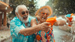 © mattegg - Photo of Funny Elderly Man and Woman Engage in Water Gun Play. Old as you feel concept.