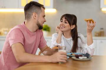 Wall Mural - Happy couple having tasty breakfast at home