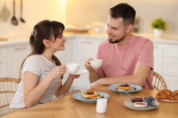 Wall Mural - Happy couple having tasty breakfast at home