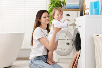 Sticker - Mother with her daughter washing baby clothes in bathroom