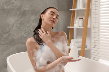 Wall Mural - Woman taking bath with shower gel in bathroom