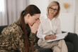 © New Africa - Psychotherapist working with military woman on sofa in office