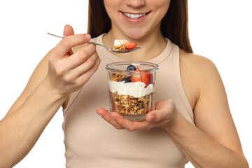 Wall Mural - Happy woman eating tasty granola with fresh berries and yogurt on white background, closeup