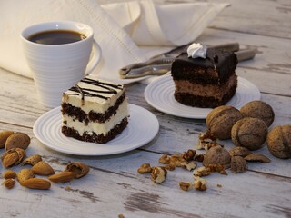 Wall Mural - Closeup of two pieces of cakes with a cup of coffee on a wooden table