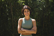 © insta_photos - Happy fit sporty active slim confident young Hispanic woman wearing sportswear enjoying summer sunny day looking at camera standing arms crossed in green nature park. Portrait.
