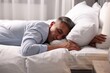 © New Africa - Businessman in office clothes sleeping on bed indoors